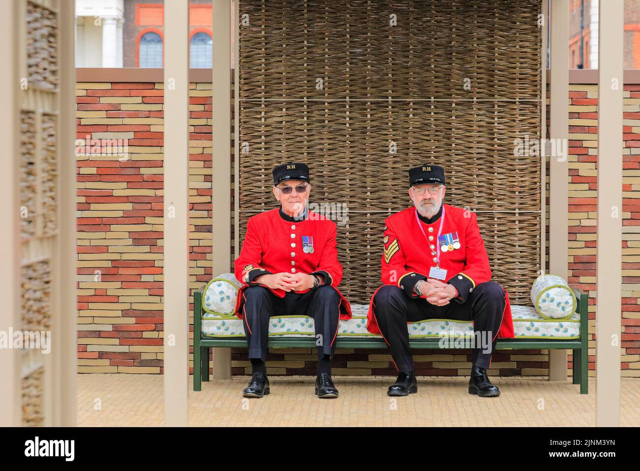 Two Chelsea Pensioners sit  in the The Stitchers’ Garden , Chelsea Flower Show, London, England Stock Photo
