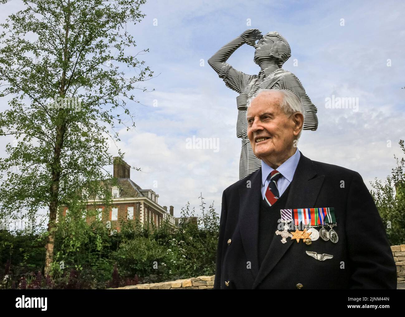WW2 RAF veteran Lt Colin Bell, 102 yrs, with the sculpture of a young pilot in the RAF Benevolent Fund garden, Chelsea Flower Show Stock Photo