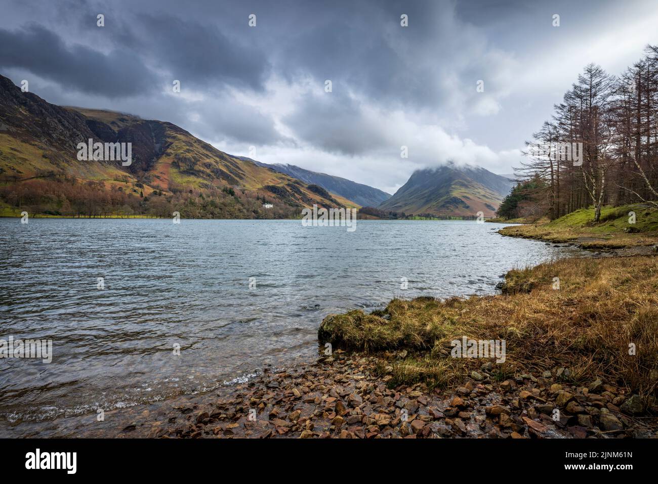 The Buttermere shoreline with Fleetwith Pike and the Honiston Pass in the background, Cumbria, England Stock Photo