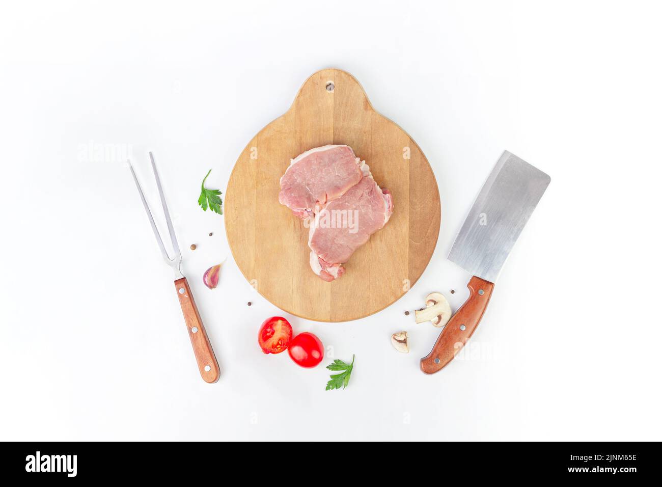 Raw meat with garlic, tomato, spice, pepper, champignon meat fork and knife Stock Photo