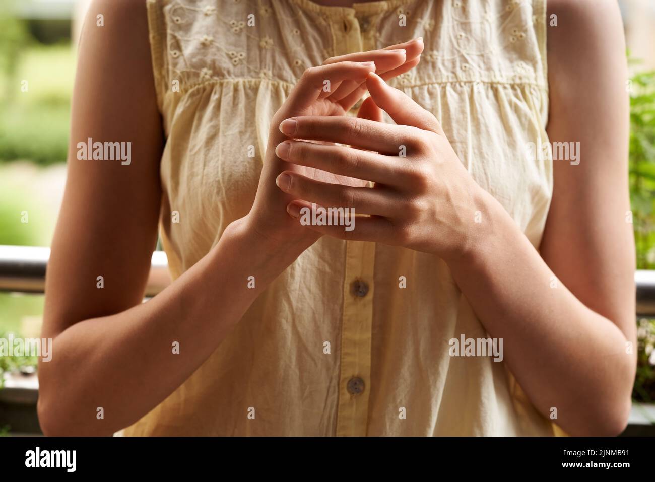 Girl doing EFT or emotional freedom technique - tapping on the side of the hand point Stock Photo
