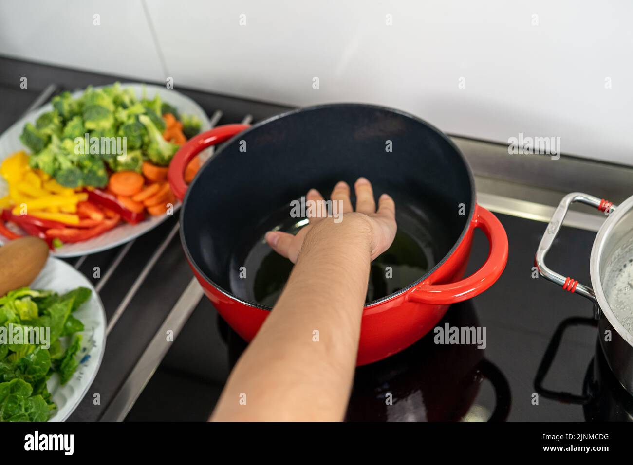 Hand controlling the temperature of the pot Stock Photo