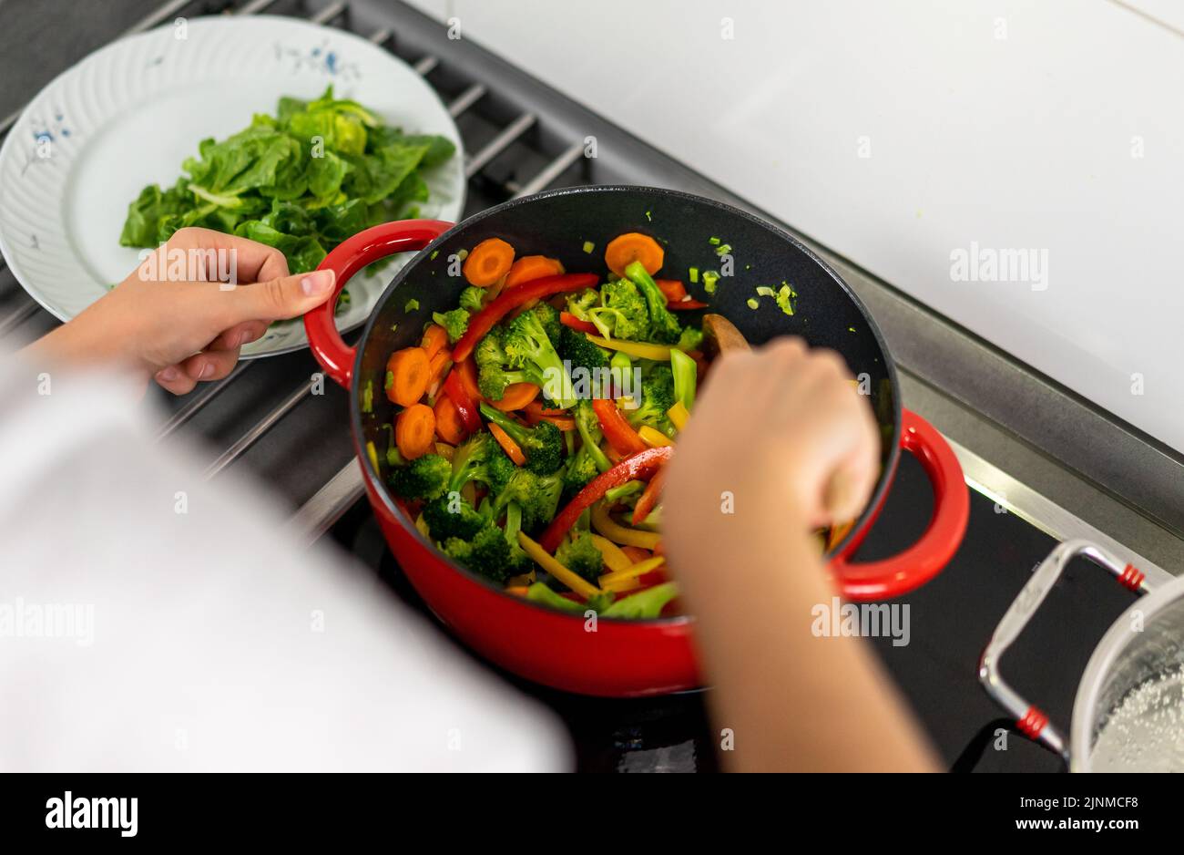 vegetables cooked in a pot by a young woman Stock Photo