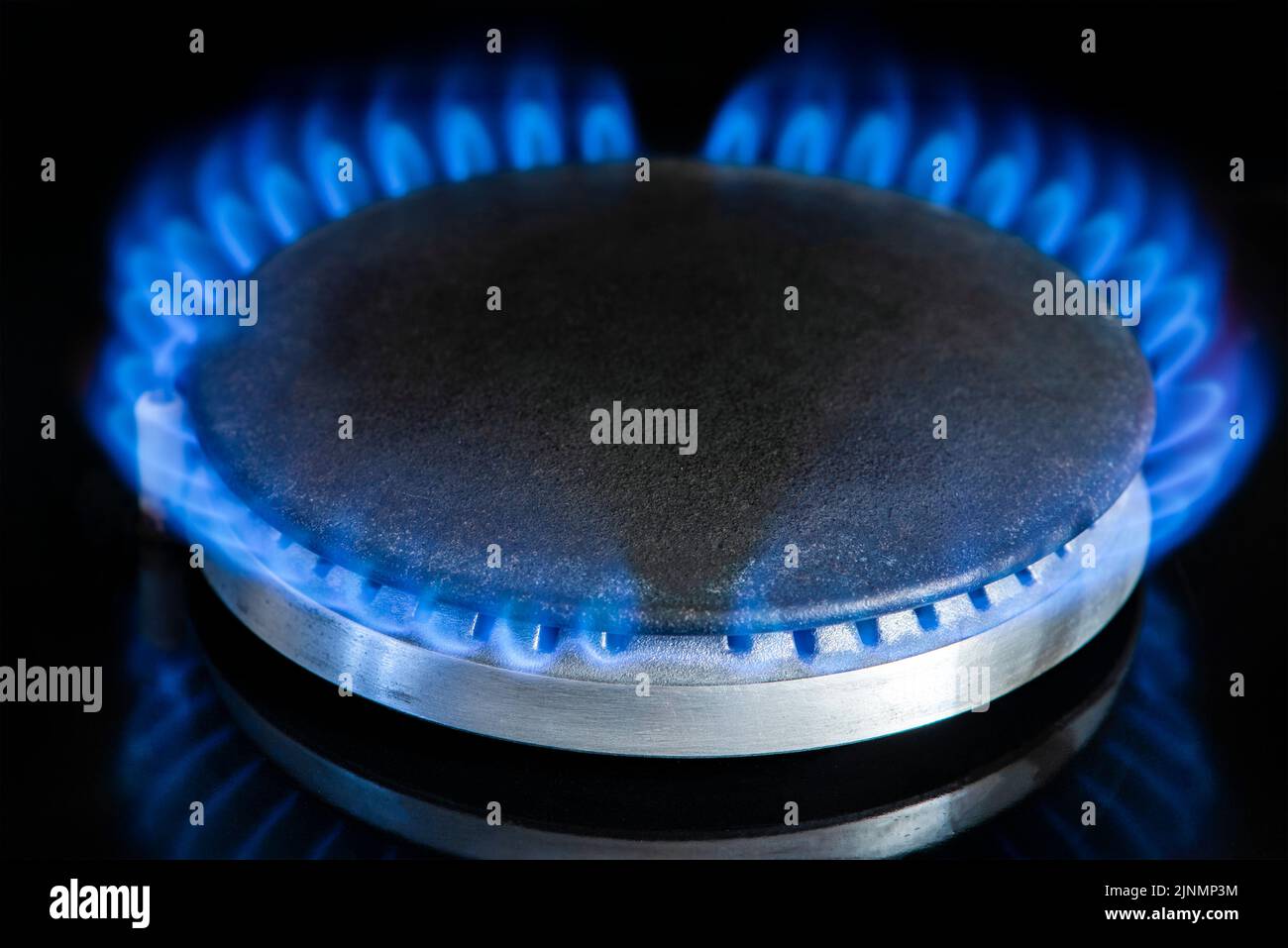 Gas stove on a black background. Fragment of a gas kitchen stove with a