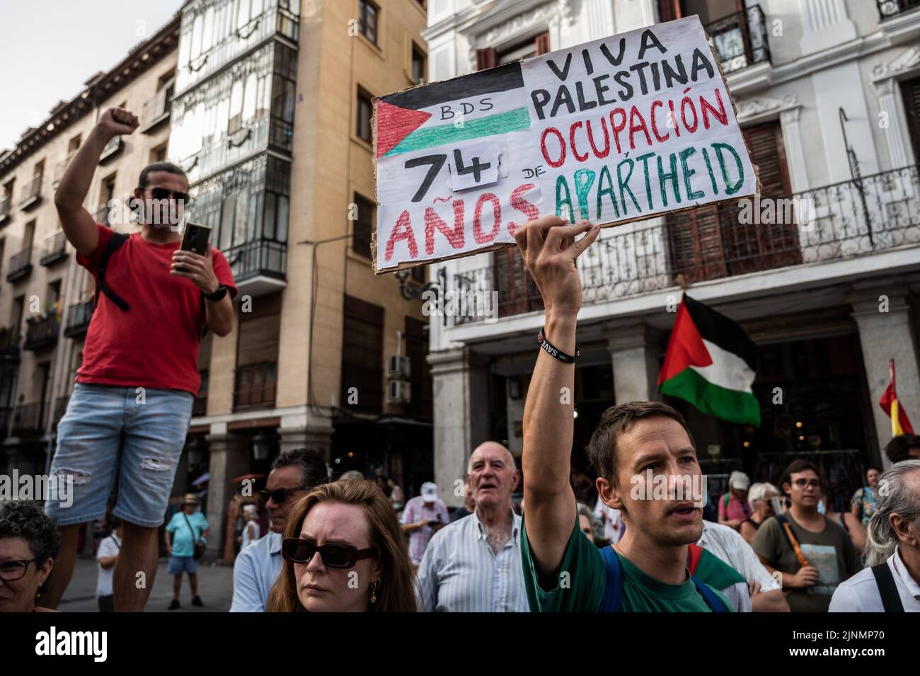 Madrid, Spain. 12th Aug, 2022. Protesters are seen holding placards and Palestine flags during a demonstration where the Palestinian community gathered in front of the Ministry of Foreign Affairs to protest against the recent military offensive on the Gaza Strip by Israel, which has caused the death of 46 people, 16 of them minors. Credit: Marcos del Mazo/Alamy Live News Stock Photo