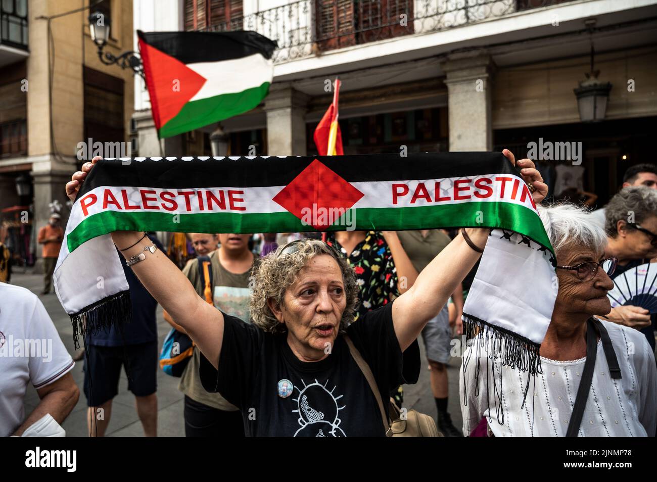 Madrid, Spain. 12th Aug, 2022. Protesters are seen holding Palestine flags during a demonstration where the Palestinian community gathered in front of the Ministry of Foreign Affairs to protest against the recent military offensive on the Gaza Strip by Israel, which has caused the death of 46 people, 16 of them minors. Credit: Marcos del Mazo/Alamy Live News Stock Photo