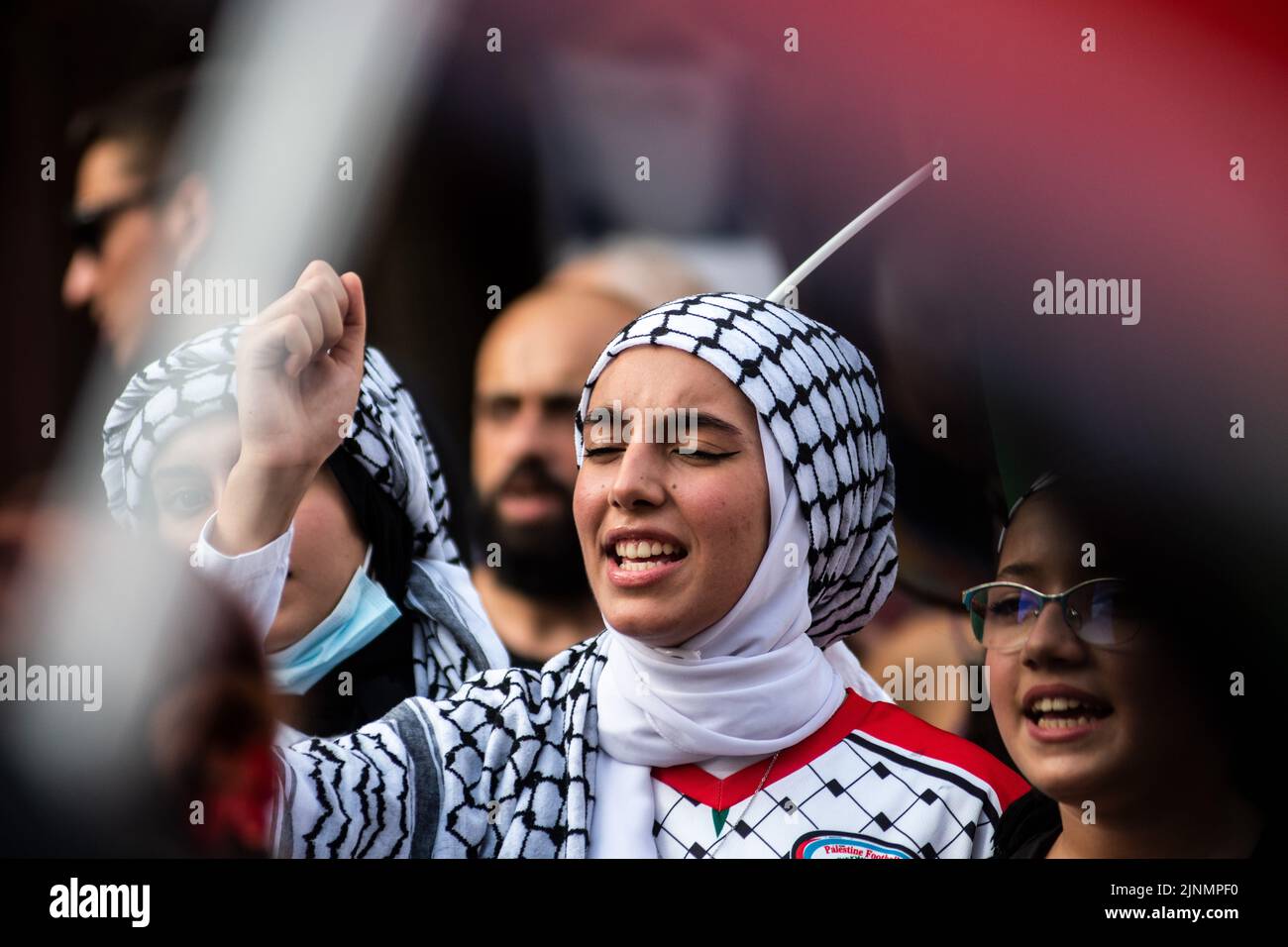 Madrid, Spain. 12th Aug, 2022. A woman raising her fist protesting during a demonstration where the Palestinian community gathered in front of the Ministry of Foreign Affairs to protest against the recent military offensive on the Gaza Strip by Israel, which has caused the death of 46 people, 16 of them minors. Credit: Marcos del Mazo/Alamy Live News Stock Photo