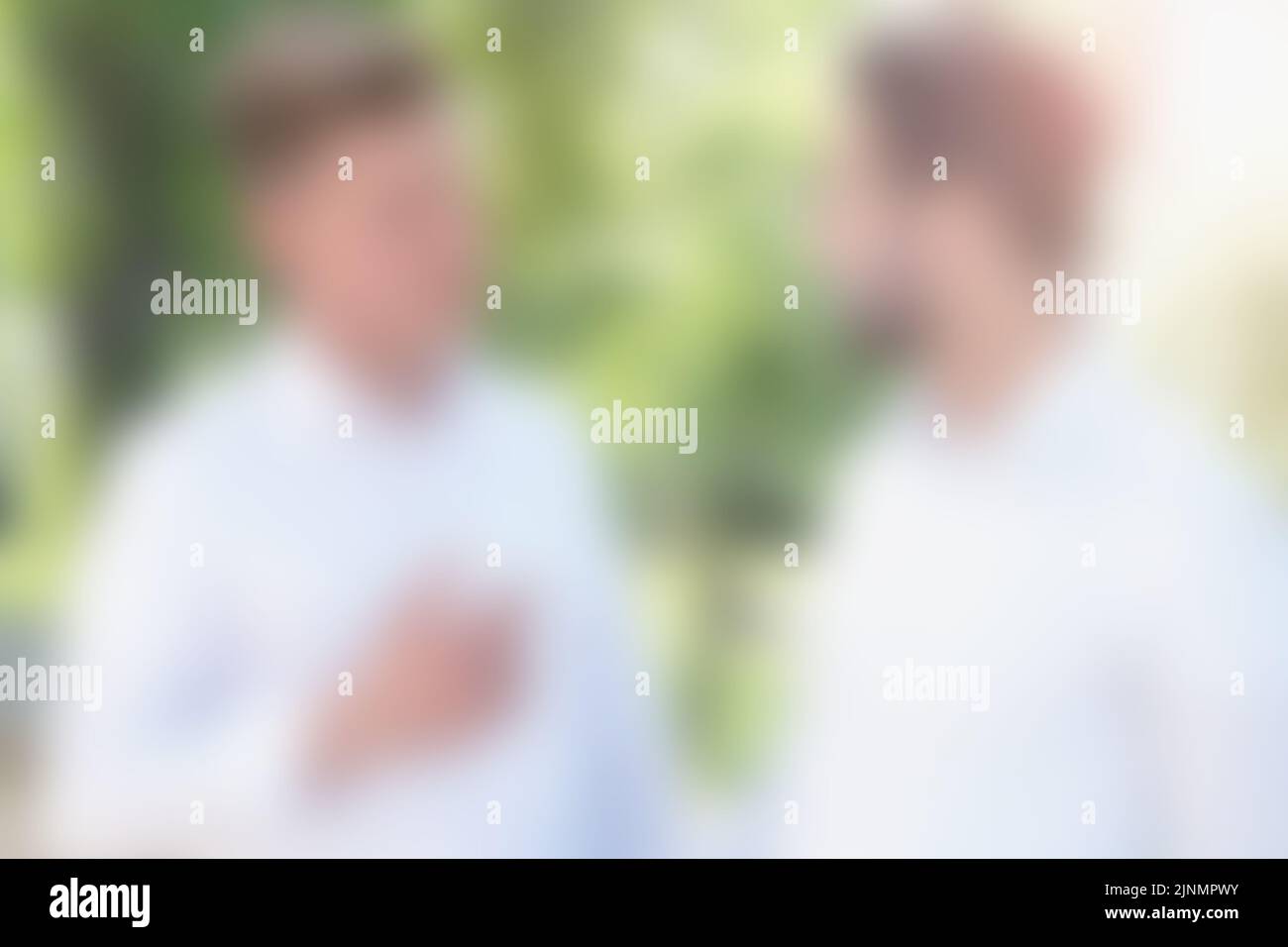 blurry background of two young men having a conversation Stock Photo