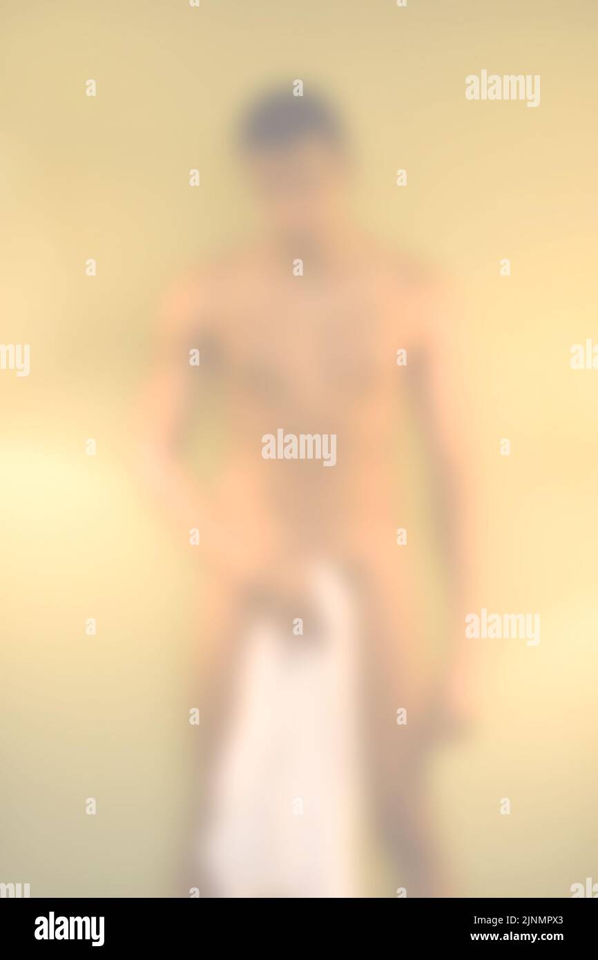 blurry background with naked man holding a towel Stock Photo