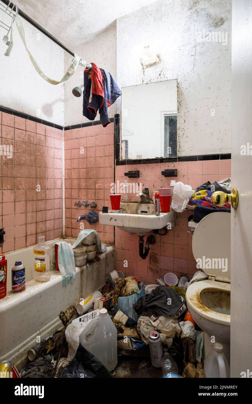 A filthy apartment bathroom inside a hoarder's apartment. This building has since been demolished Stock Photo