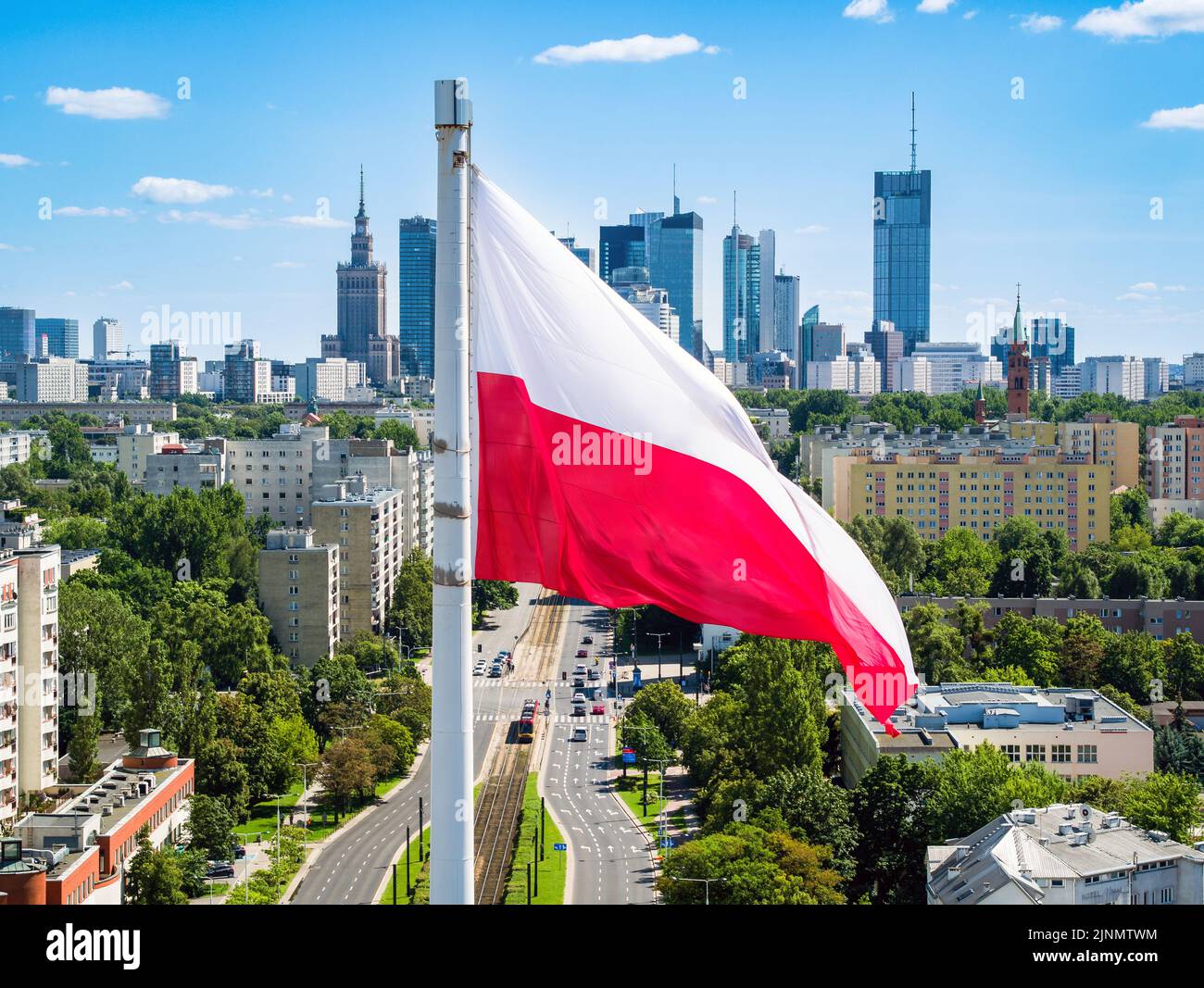 Polish national flag against skyscrapers in Warsaw city center, aerial landscape under blue sky Stock Photo