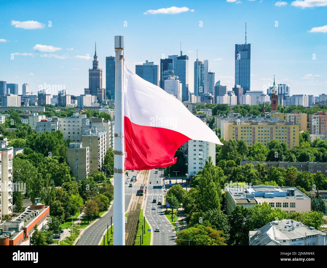 Polish national flag against skyscrapers in Warsaw city center, aerial landscape under blue sky Stock Photo
