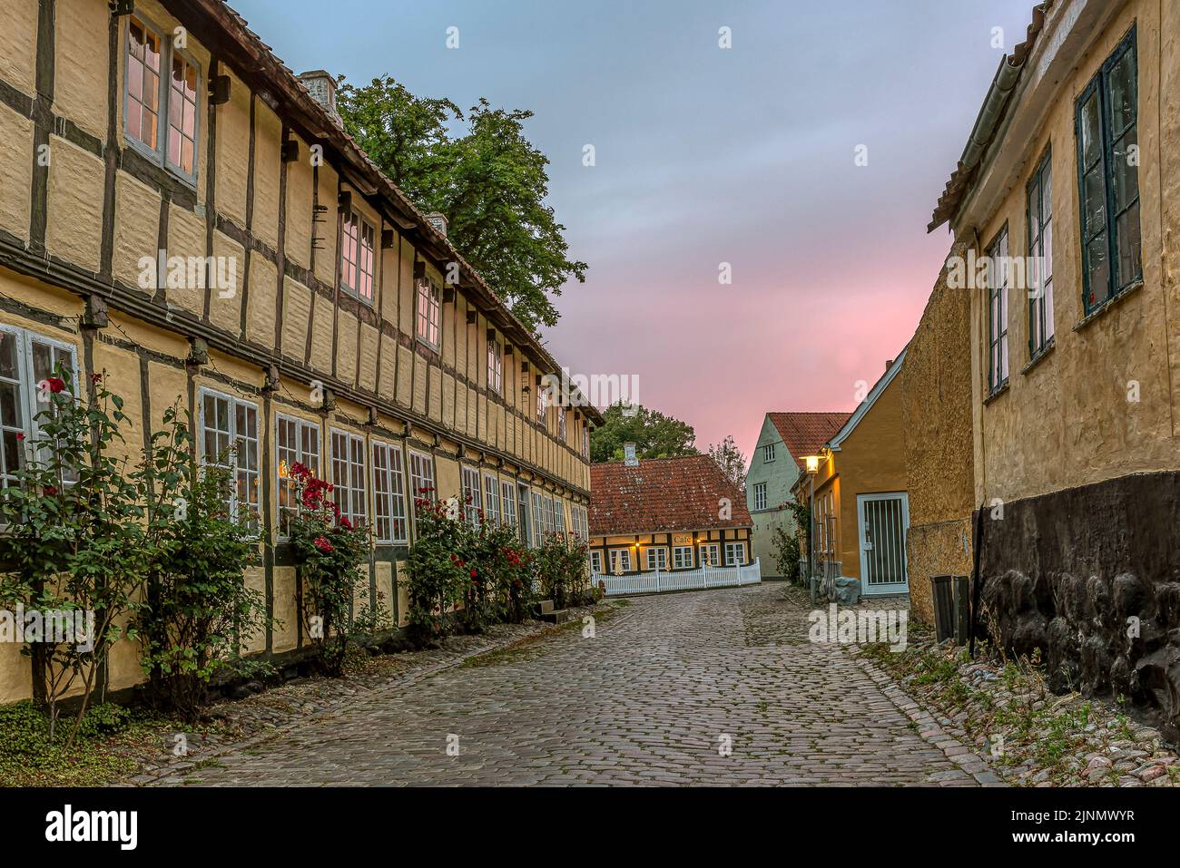 half-timbered house on a cobbled street at twilight hour in a small town, Mariager, Denmark, August 7 2022 Stock Photo