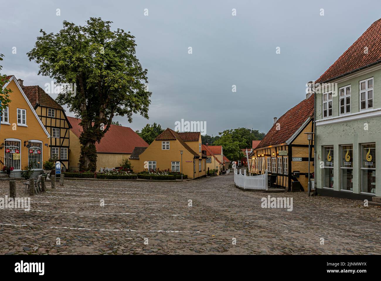 Cobbled square with roses and vintage timber framed houses in the dusk evening light, Mariager, Denmark, August 7, 2022 Stock Photo