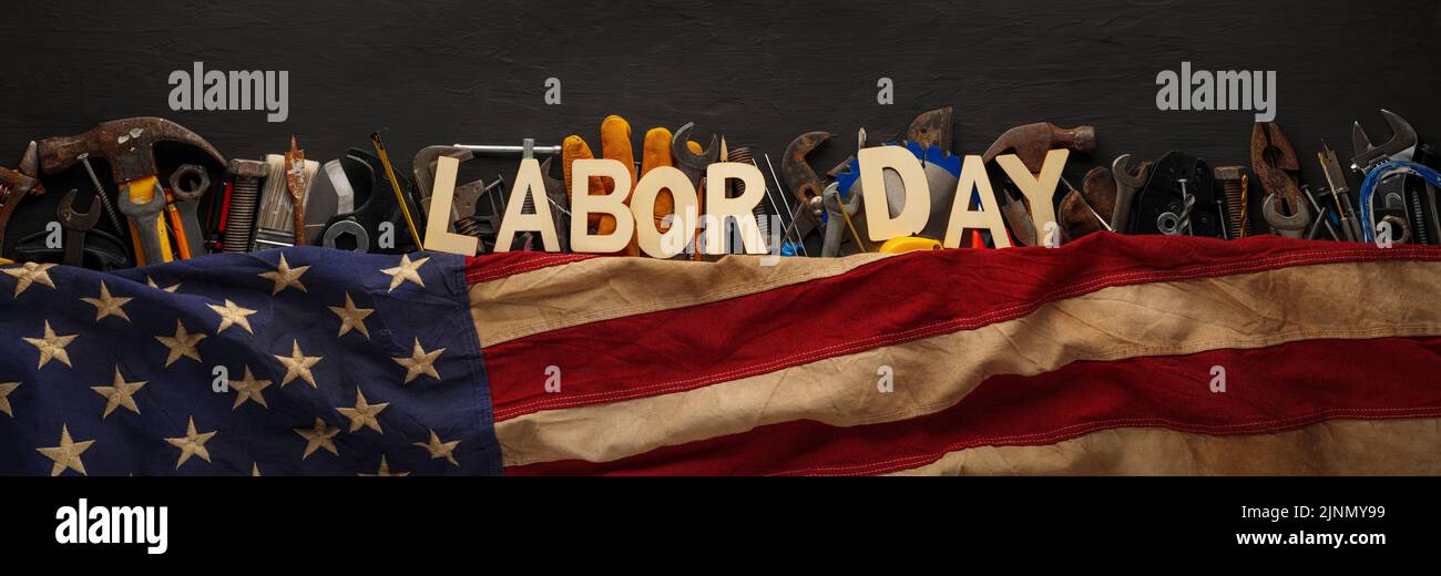 Worn and used collection of work tools with US American flag and Labor Day text. Stock Photo