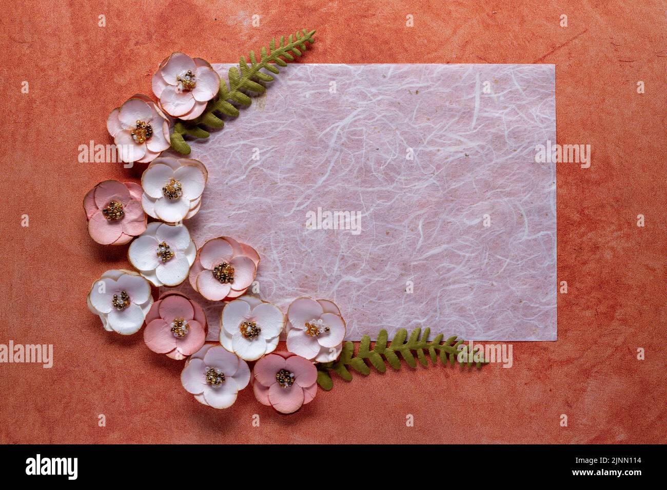 fiber paper and paper flowers on textured orange background Stock Photo