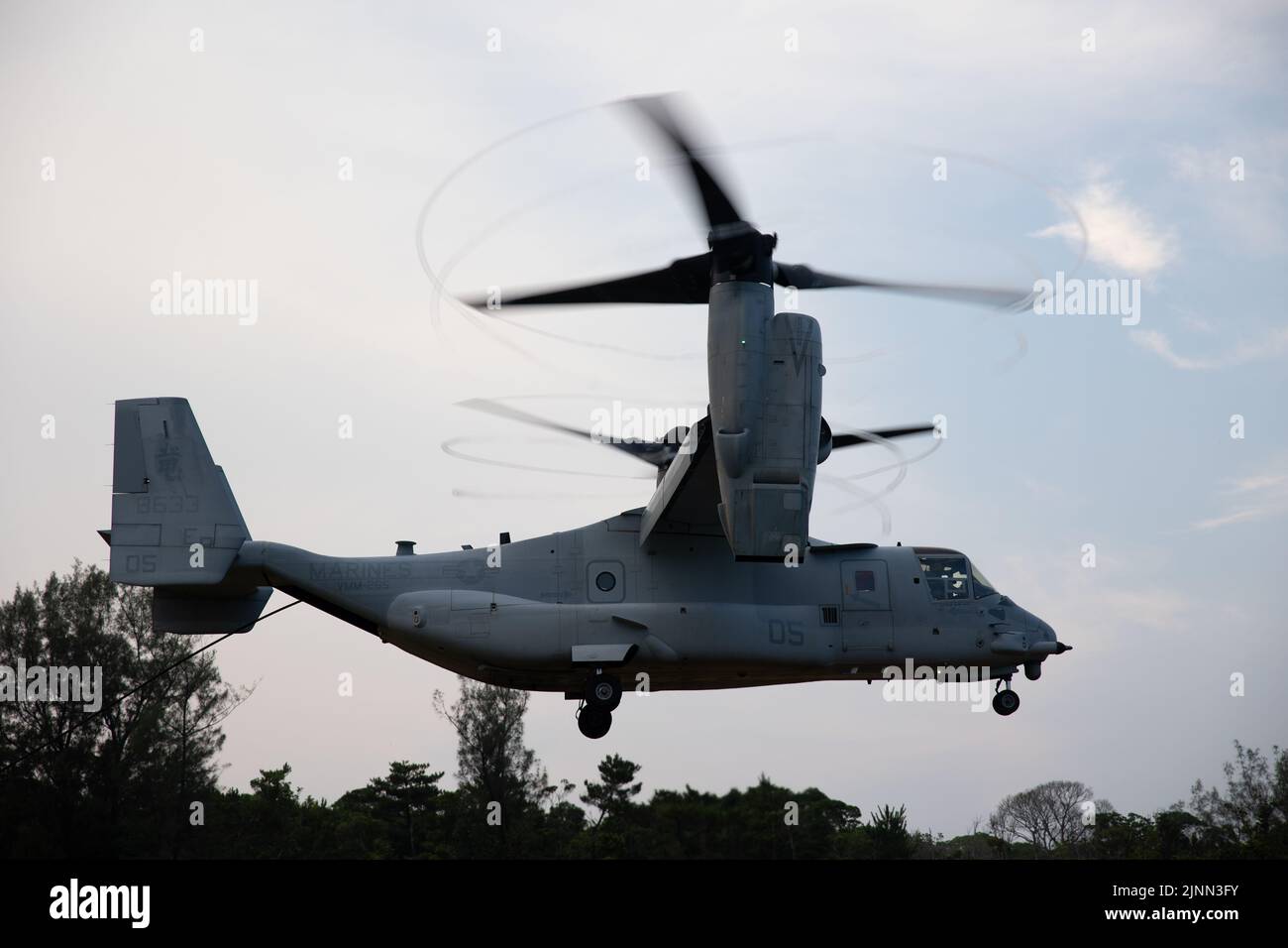 U.S. Marines with Marine Wing Support Squadron (MWSS) 171 take off in an MV-22B Osprey assigned to Marine Medium Tiltrotor Squadron (VMM) 265 during a Fast Rope Masters Course (FRMC) at Landing Zone Sterling, Okinawa, Japan, July 26, 2022. Fast roping allows Marines to enter landing zones that are too dangerous for helicopters to safely land. Fast Rope and Helicopter Rope Suspension Training teaches Marines proper knots and rappelling techniques, and builds confidence for maneuvering from air to ground. (U.S. Marine Corps photo by Pfc. Justin J. Marty) Stock Photo