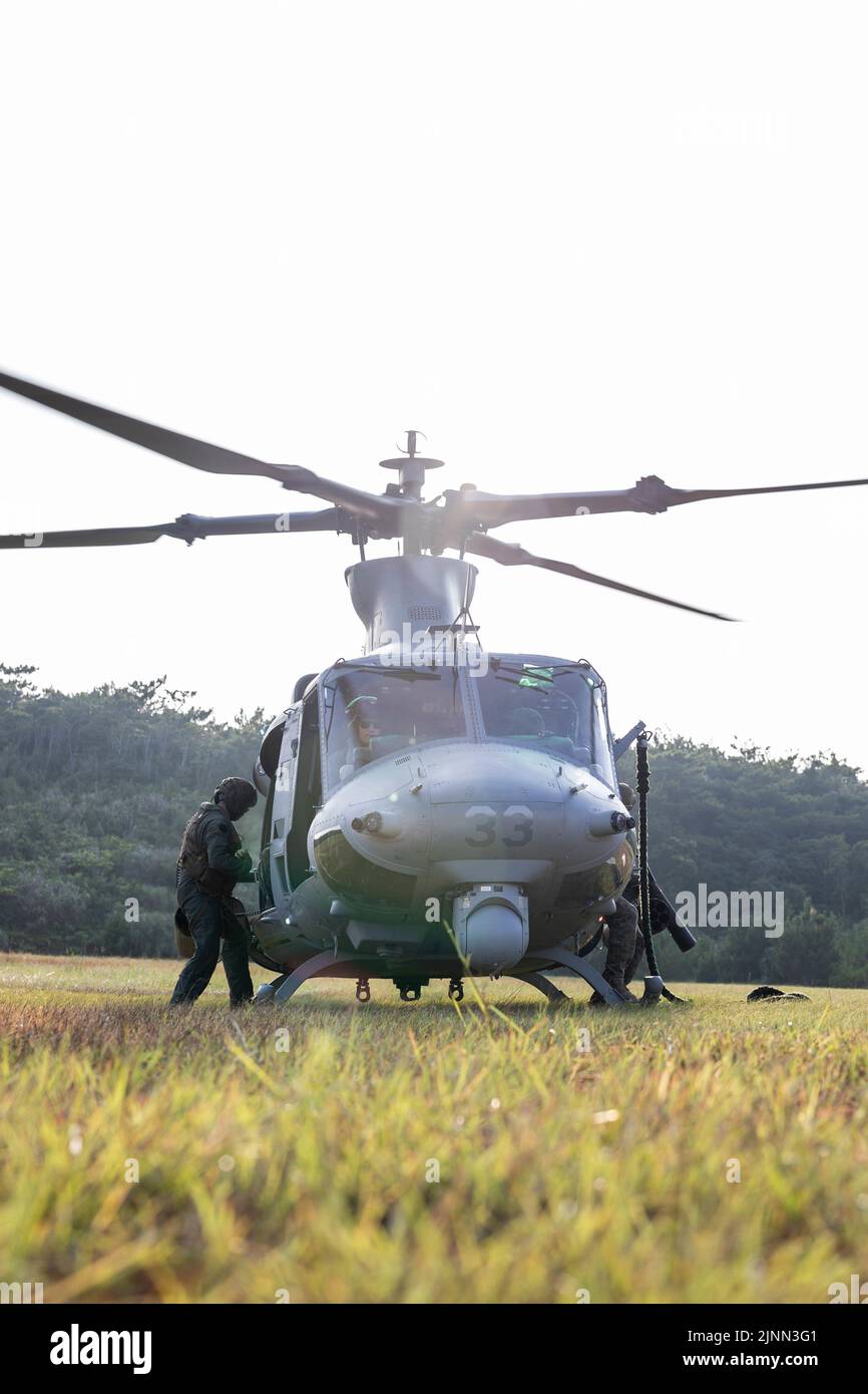 A U.S. Marine Corps UH-1Y Venom helicopter prepares to take off during a Fast Rope Masters Course (FRMC) at Landing Zone Sterling, Okinawa, Japan, July 27, 2022. Fast roping allows Marines to enter landing zones that are too dangerous for helicopters to safely land. Fast Rope and Helicopter Rope Suspension Training teaches Marines proper knots and rappelling techniques, and builds confidence for maneuvering from air to ground. (U.S. Marine Corps photo by Pfc. Justin J. Marty) Stock Photo