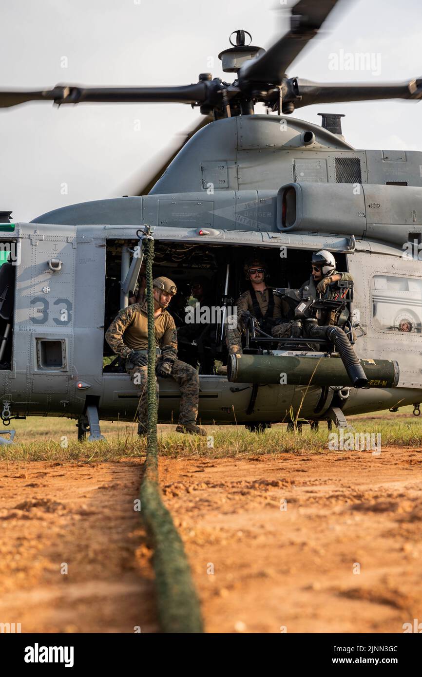 U.S. Marines with Marine Wing Support Squadron (MWSS) 171 prepare to fast rope out of a UH-1Y Venom assigned to Marine Light Attack Helicopter Squadron (HMLA) 469 during a Fast Rope Masters Course (FRMC) at Landing Zone Sterling, Okinawa, Japan, July 27, 2022. Fast roping allows Marines to enter landing zones that are too dangerous for helicopters to safely land. Fast Rope and Helicopter Rope Suspension Training teaches Marines proper knots and rappelling techniques, and builds confidence for maneuvering from air to ground. (U.S. Marine Corps photo by Pfc. Justin J. Marty) Stock Photo