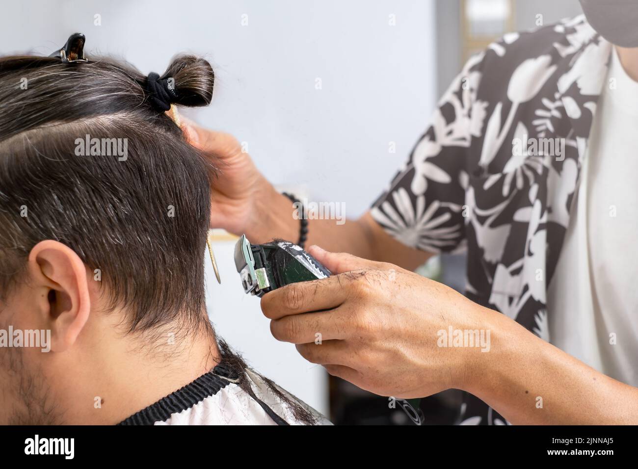 Men's haircut using a razor in the salon Stock Photo
