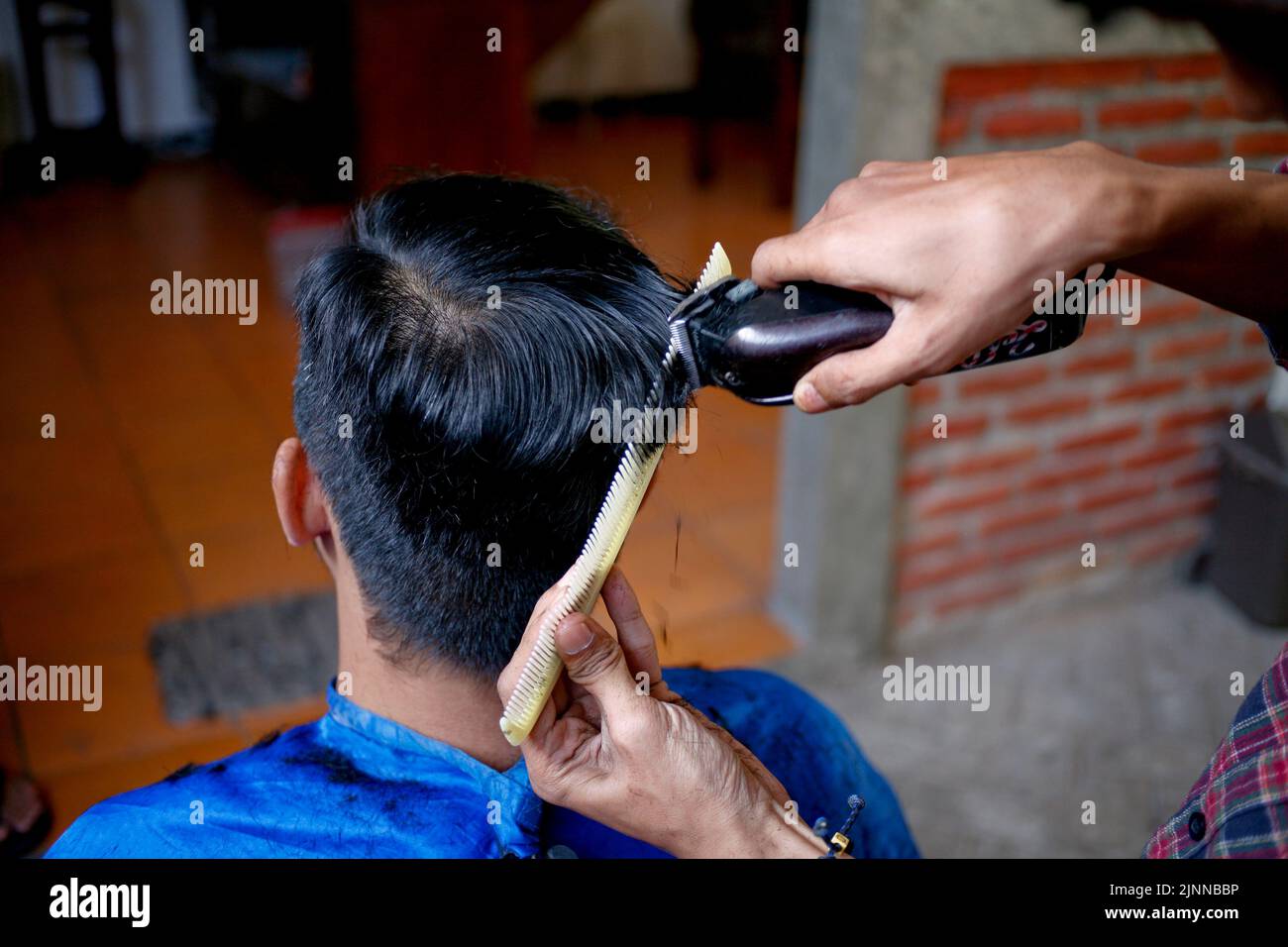 Asian barber cutting black hair with electric clipper Stock Photo Alamy