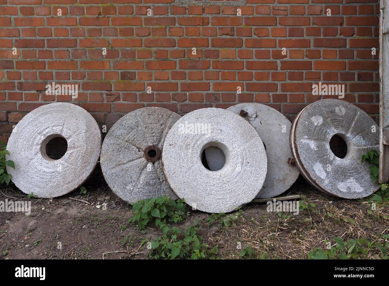Discarded millstones on a clinker wall, Mecklenburg-Western Pomerania, Germany Stock Photo
