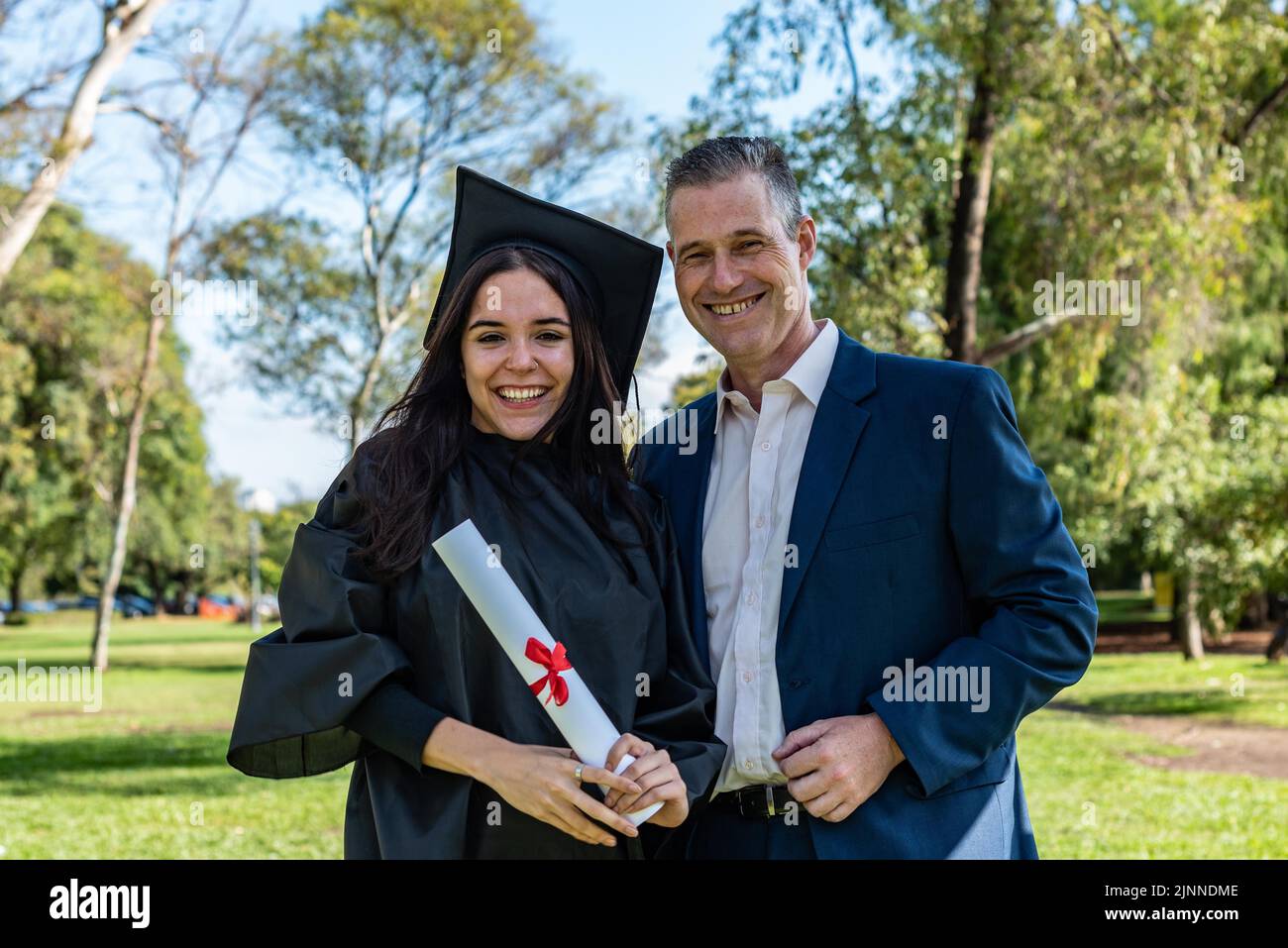 Happy caucasian graduated girl with her father on her graduation day ...