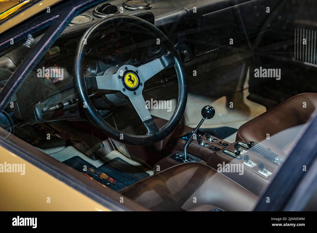 View into interior of Ferrari 512 BB from 70s 1977 with steering wheel with logo jumping horse Cavallino Rampante and lever of manual gear shift Stock Photo