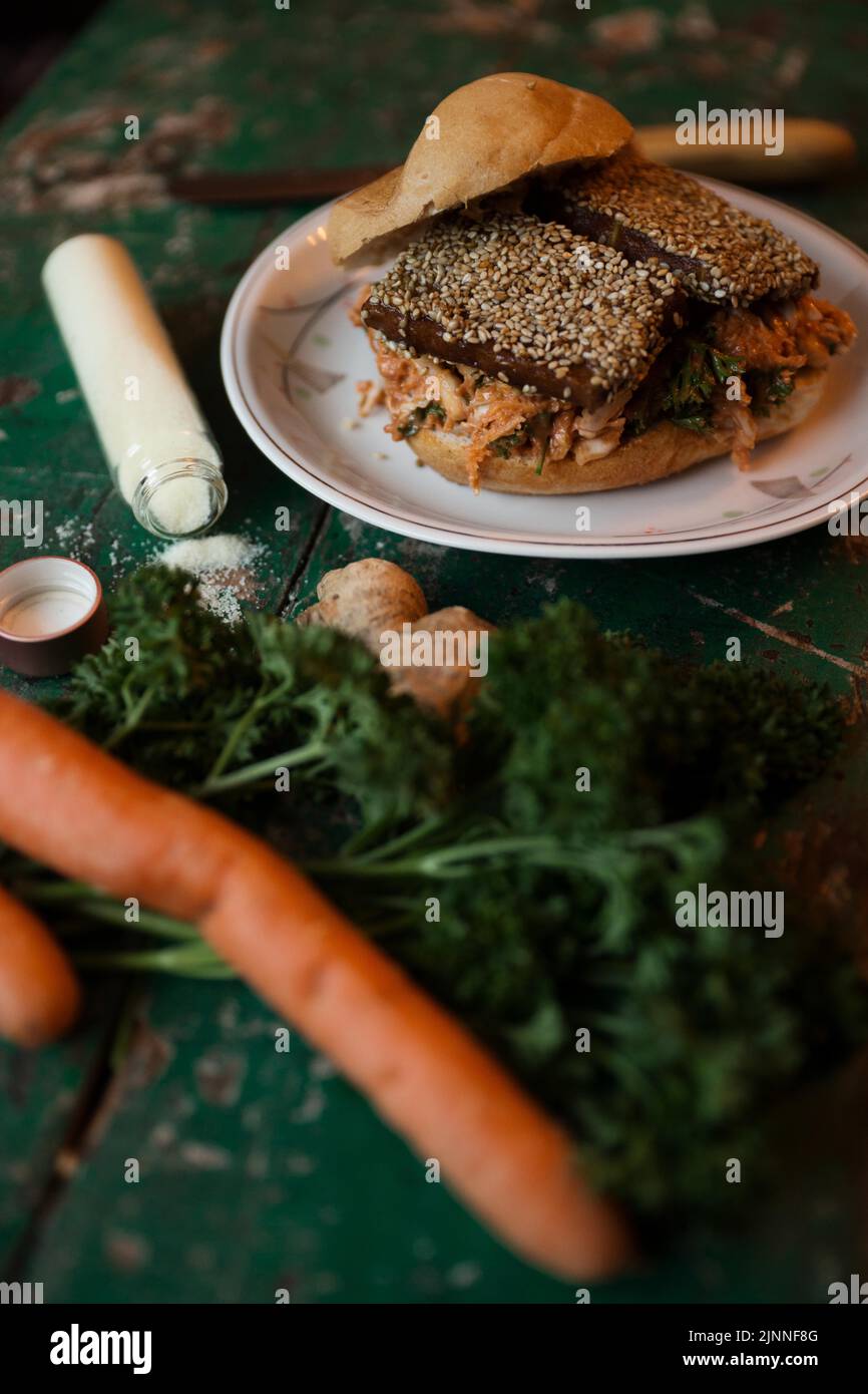 Vegan tofu burger with sesame seeds, carrot, ginger, parsley and salt Stock Photo