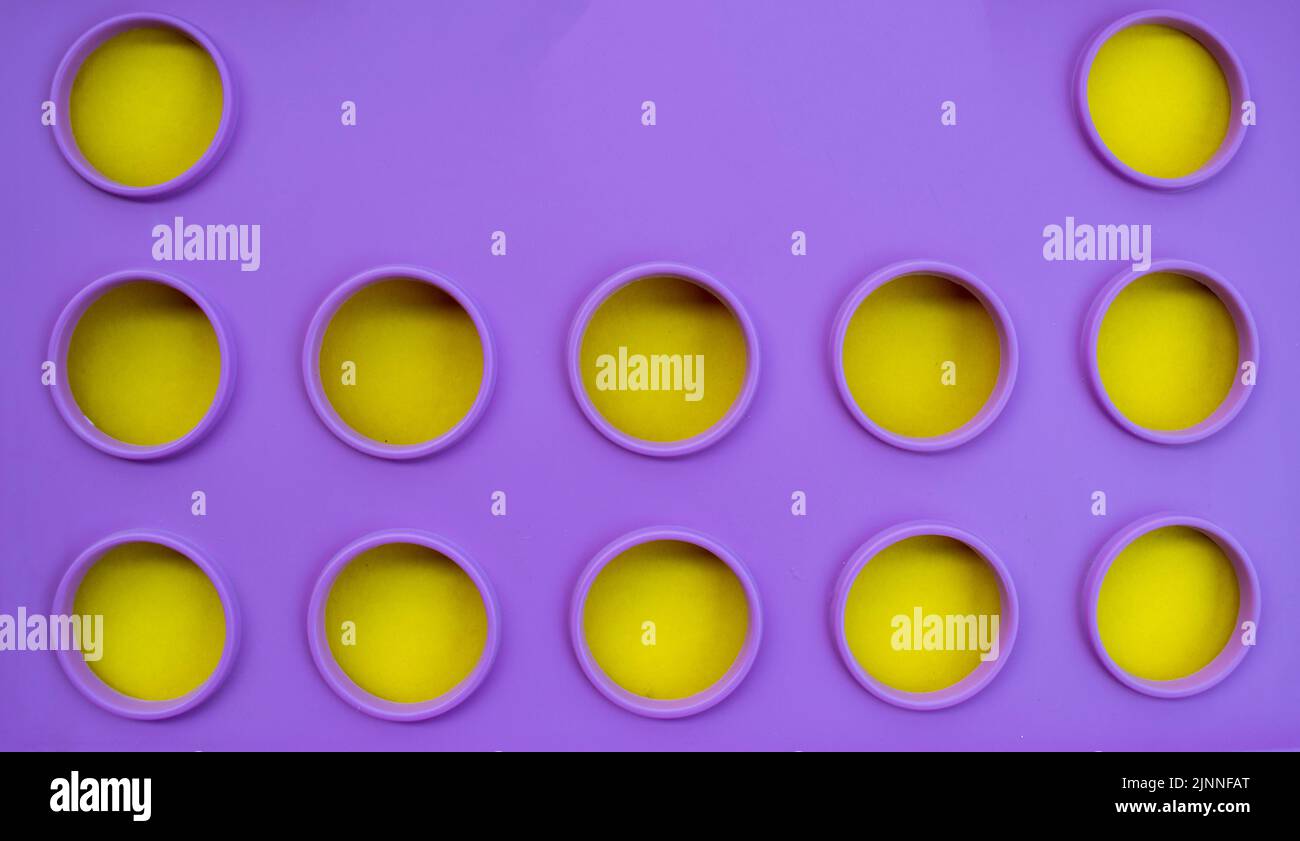A purple crate with a yellow insert makes an interesting and eye catching abstract background. Could be used for arts and crafts promotions or signage Stock Photo