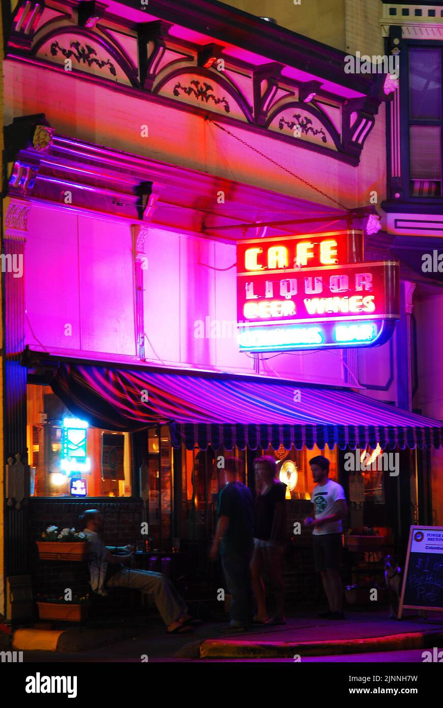 Friends gather outside a local tavern and bar at night in downtown Columbus Indiana Stock Photo