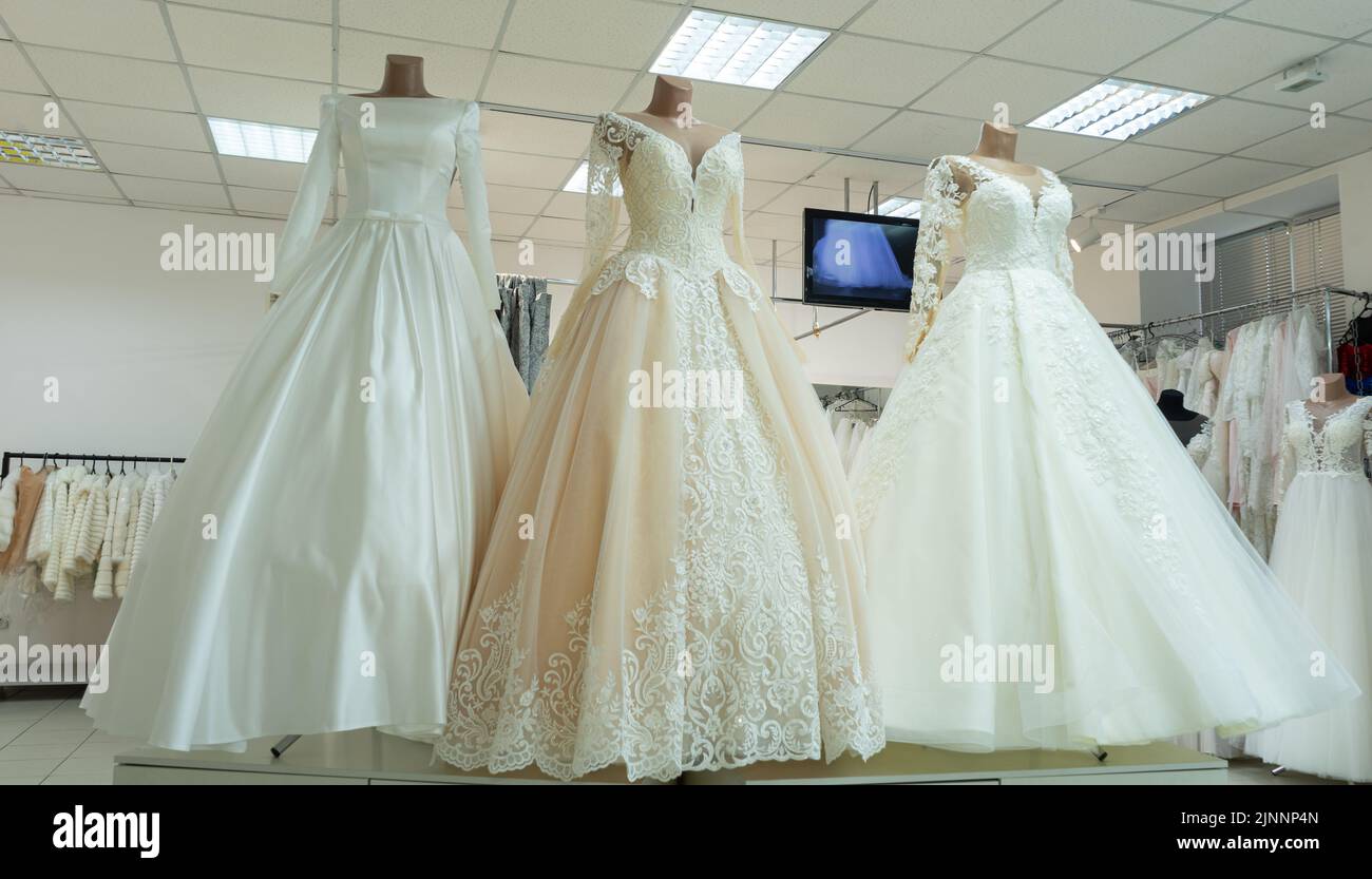 Three chic wedding dresses on mannequins. Three different models of beautiful wedding dresses Stock Photo