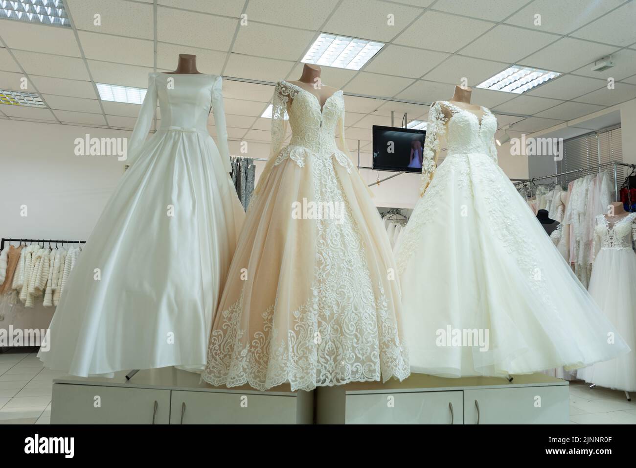 Three chic wedding dresses on mannequins. Three different models of beautiful wedding dresses Stock Photo