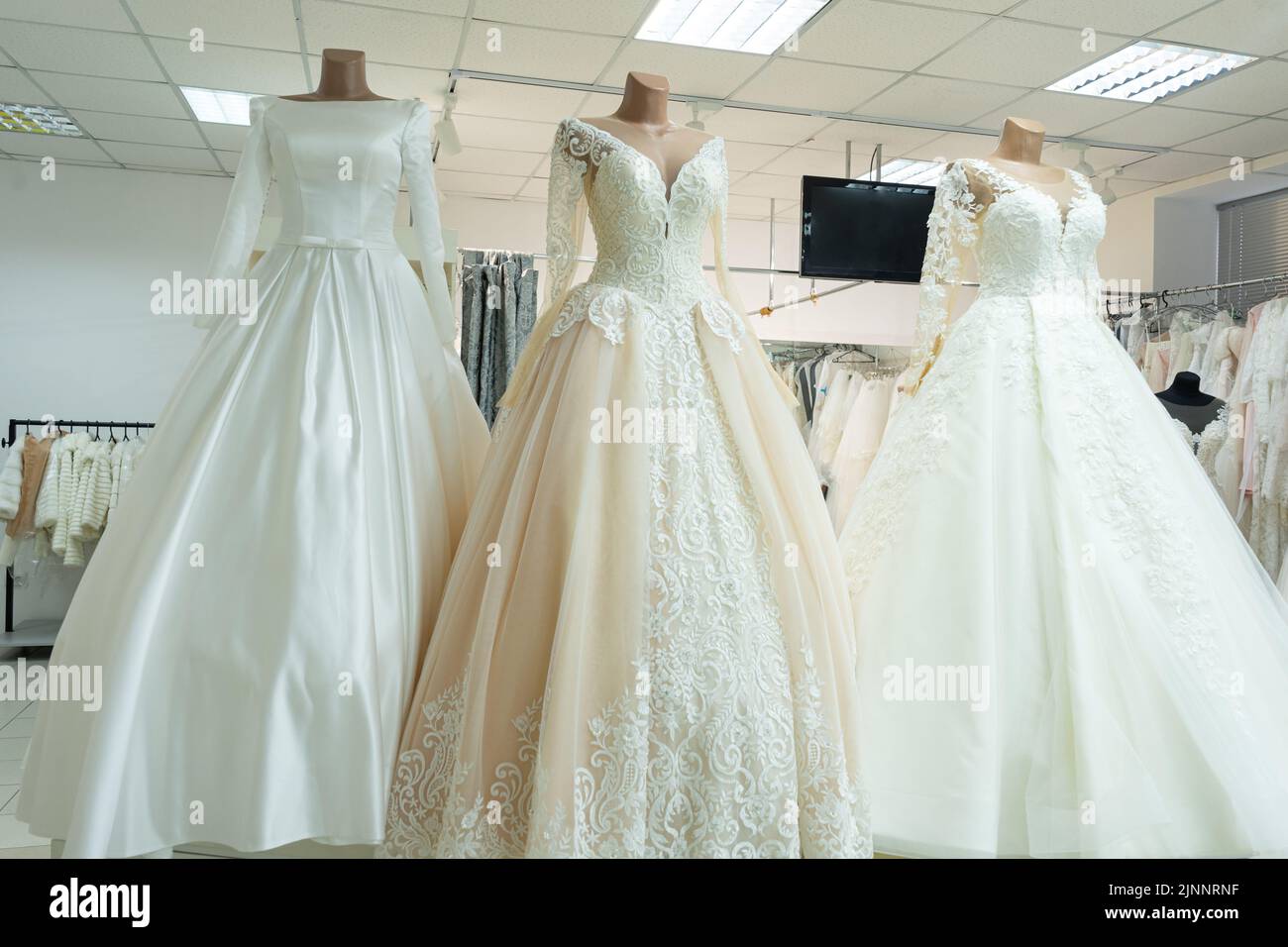 Three chic wedding dresses on mannequins. Three different models of beautiful wedding dresses Stock Photo