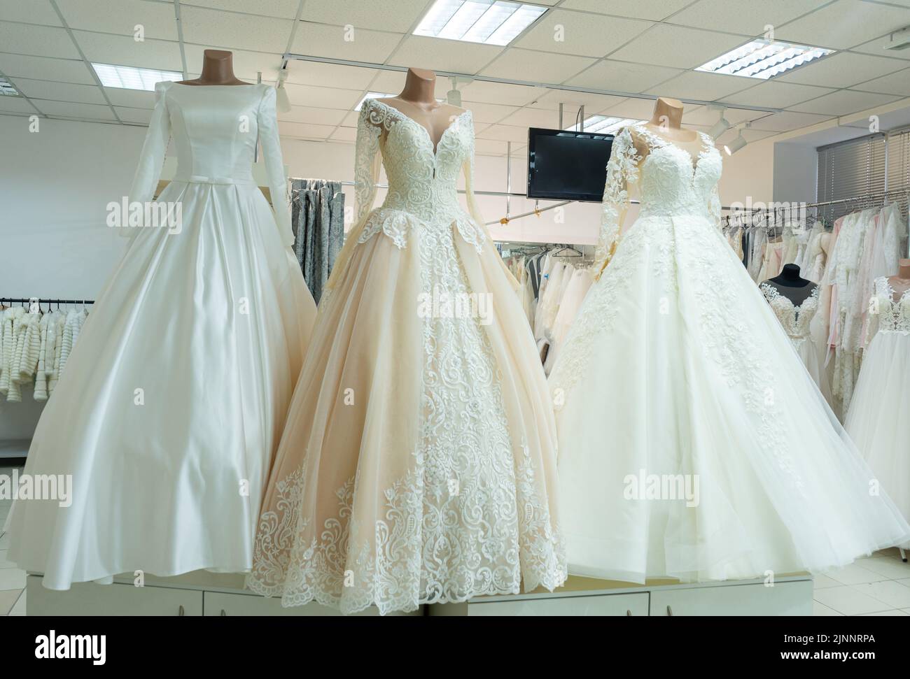 Three chic wedding dresses on mannequins. Three different models of beautiful wedding dresses Stock Photo