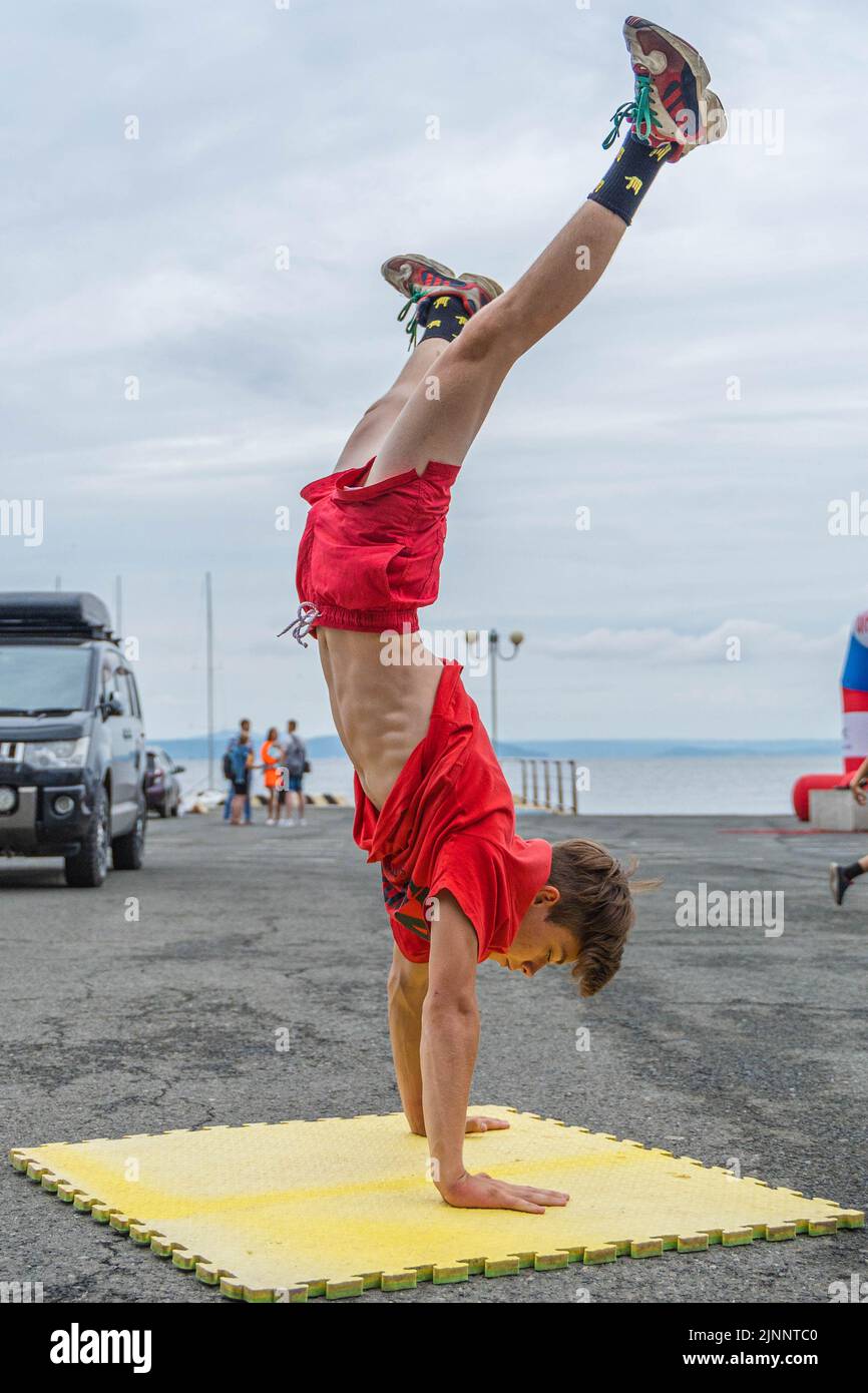 Vladivostok, Russia. 13th Aug, 2022. A young man does a handstand on the Sportsman's Day of Russia in Vladivostok, Russia, Aug. 13, 2022. The Sportsman's Day of Russia falls on the second Saturday of every August. Credit: Guo Feizhou/Xinhua/Alamy Live News Stock Photo
