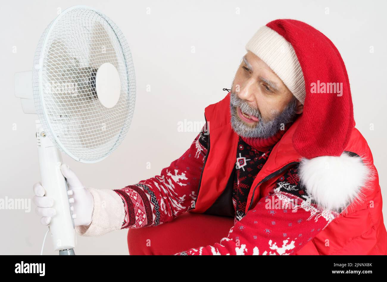 Holiday and Christmas concept. Santa Claus is cooled with a fan Stock ...