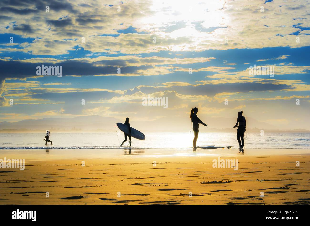 Silhouette of surfers on a beach Stock Photo