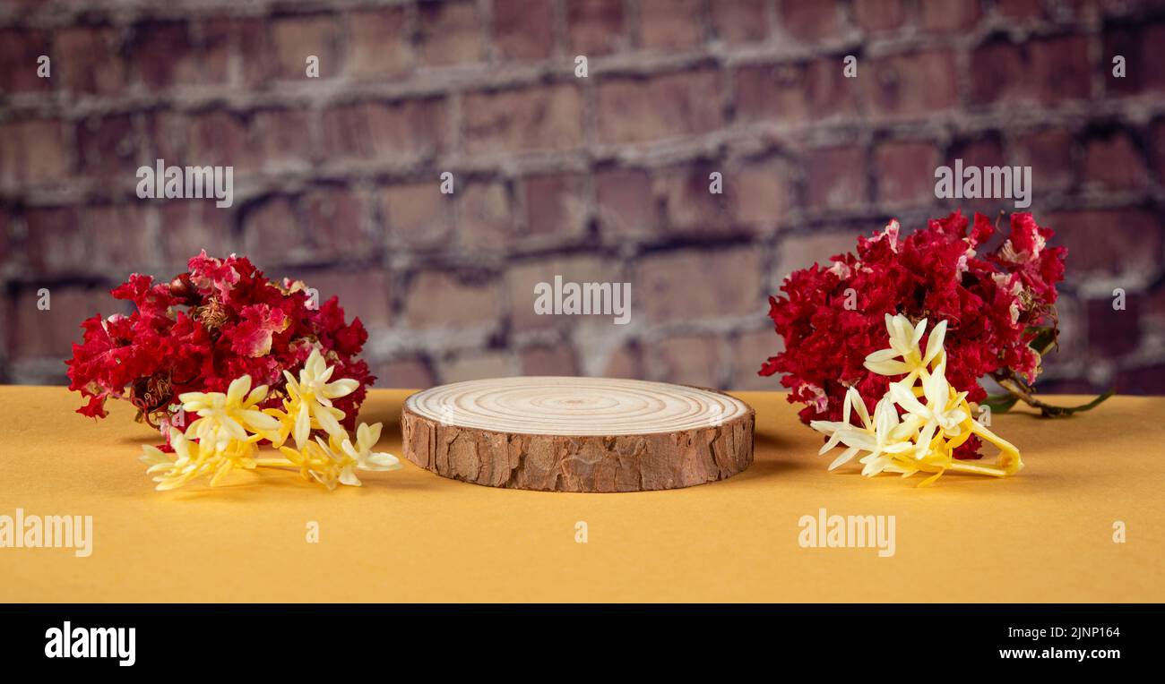 Wood podium with red natural flowers and product mockup space. Stock Photo