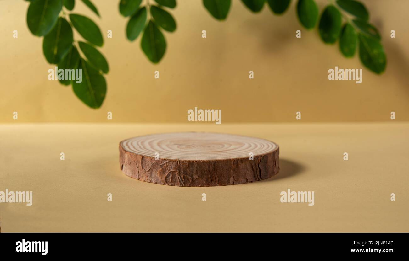 Wood Podium with natural leaf in background for herbal product mockup. Stock Photo