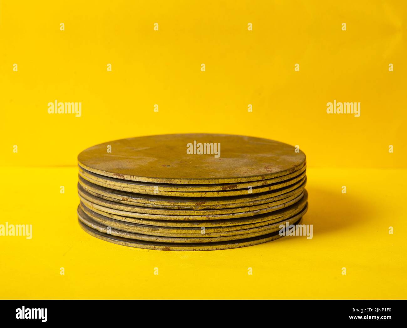 Pieces of steel pile up on yellow background for your product mockup space. Stock Photo