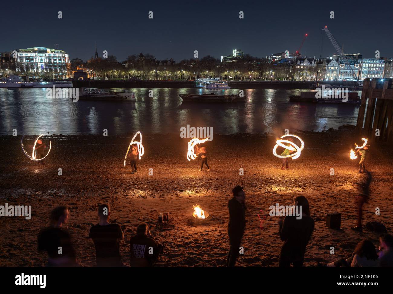 London, UK. 12th August, 2022. London Fire Spinners perform dramatic flame  acts on the Thames shore at Gabriel's Wharf during a warm Friday evening.  Credit: Guy Corbishley/Alamy Live News Stock Photo -
