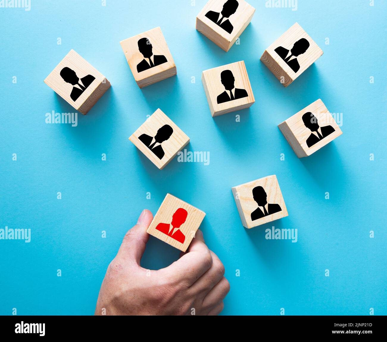 Hand choosing a wooden person block from a set. Employment choice concept Stock Photo