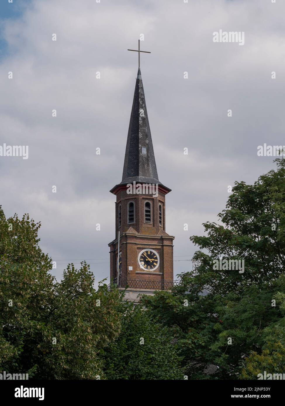 seven minutes to three o'clock on an old church tower with a cross Stock Photo