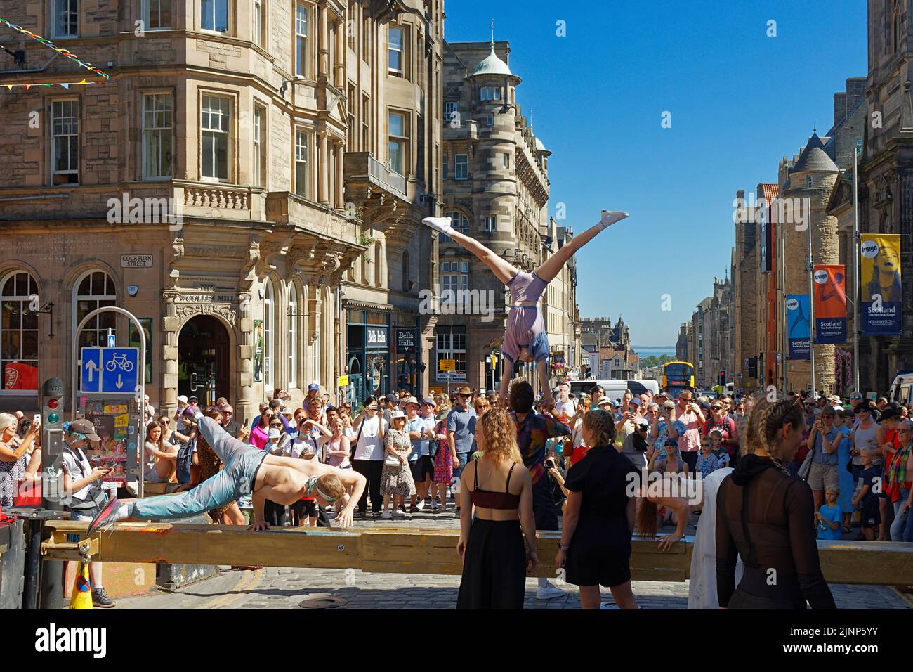 Edinburgh, Scotland, August 11, 2022 Festival Fringe in the Royal Mile acrobats performing on a bar and from the hands supported by an aid Stock Photo
