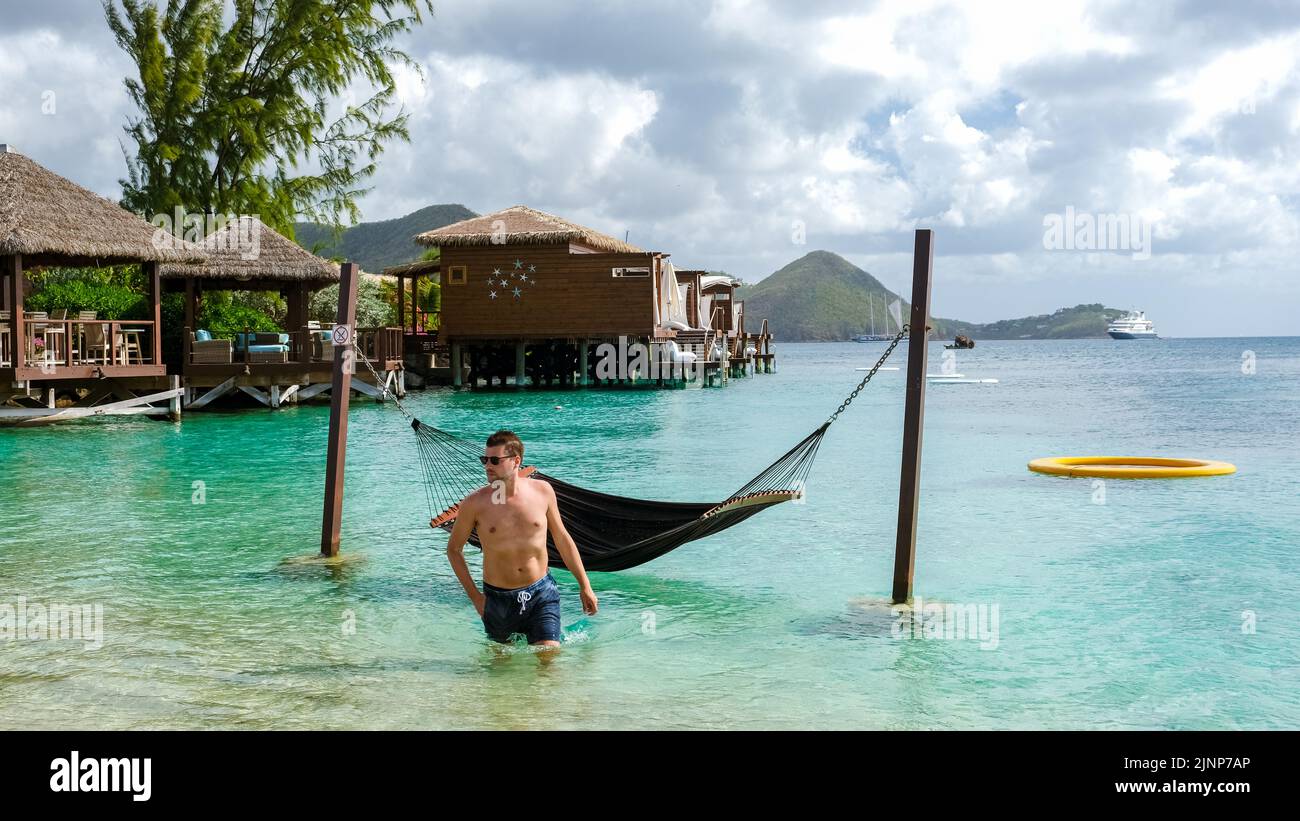 young men in hammocks in the ocean at the beach of the tropical Island