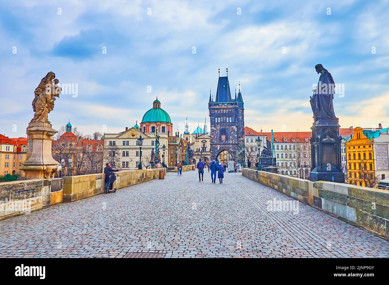 The Old Town Bridge Tower of Charles Bridge with historic statues and the dome of basilica of St Francis of Assisi, Prague, Czech Republic Stock Photo