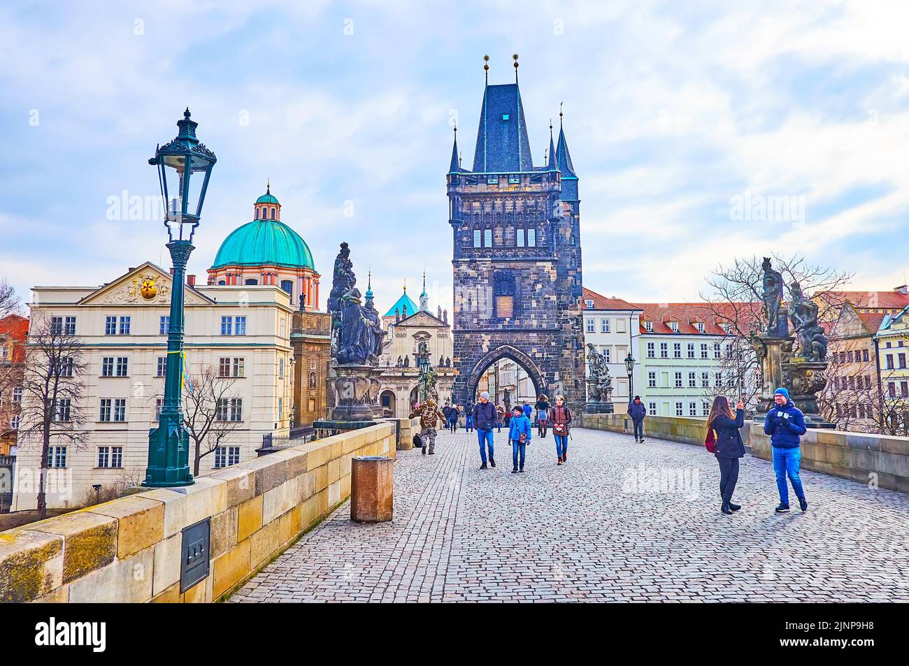 PRAGUE, CZECH REPUBLIC - MARCH 6, 2022:  The stone Gothic Old Town Bridge Tower on the Charles Bridge with beautiful stone sculptures on both sides, o Stock Photo