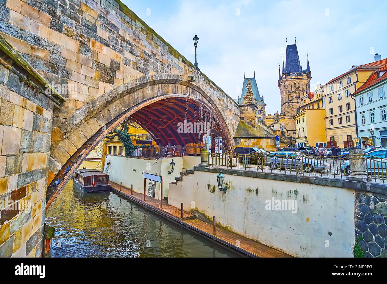 The arch of the medieval Charles Bridge and the narrow Certovka (Devil's Canal) with a view on the Mala Strana Bridge Tower in background, Prague, Cze Stock Photo