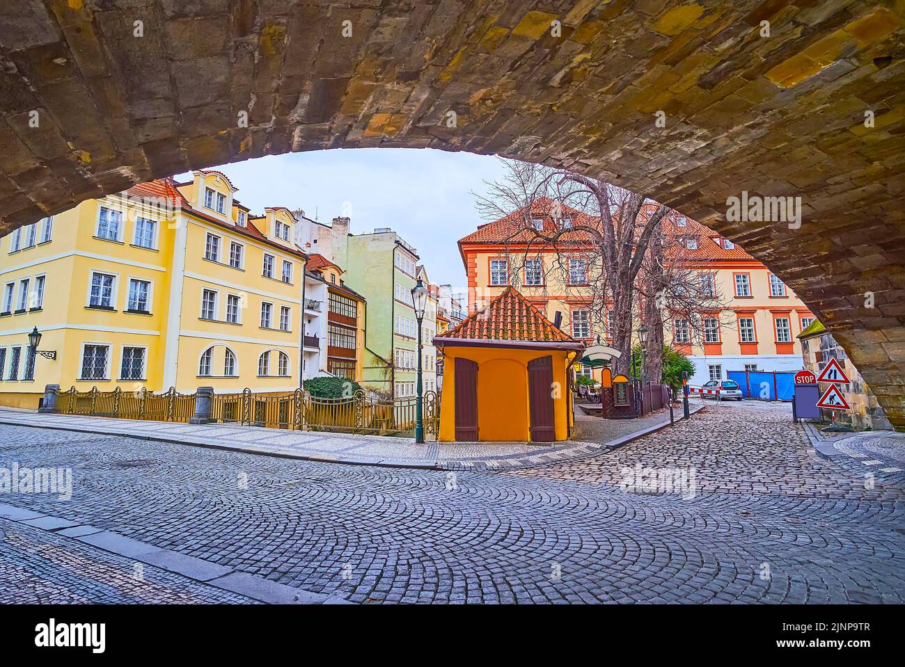 The colored houses and a small restaurant with outdoor terrace on the bank of Devil's Canal (Certovka), seen from under the Charles Bridge, Prague, Cz Stock Photo
